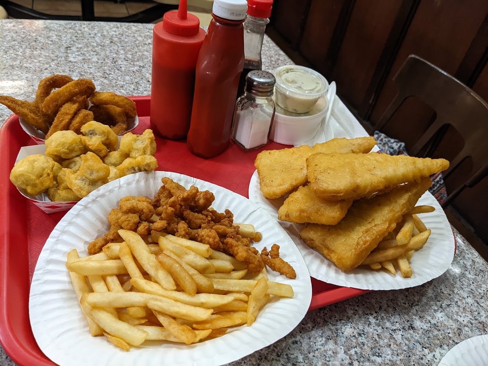 Golden fish and chips on a white plate.