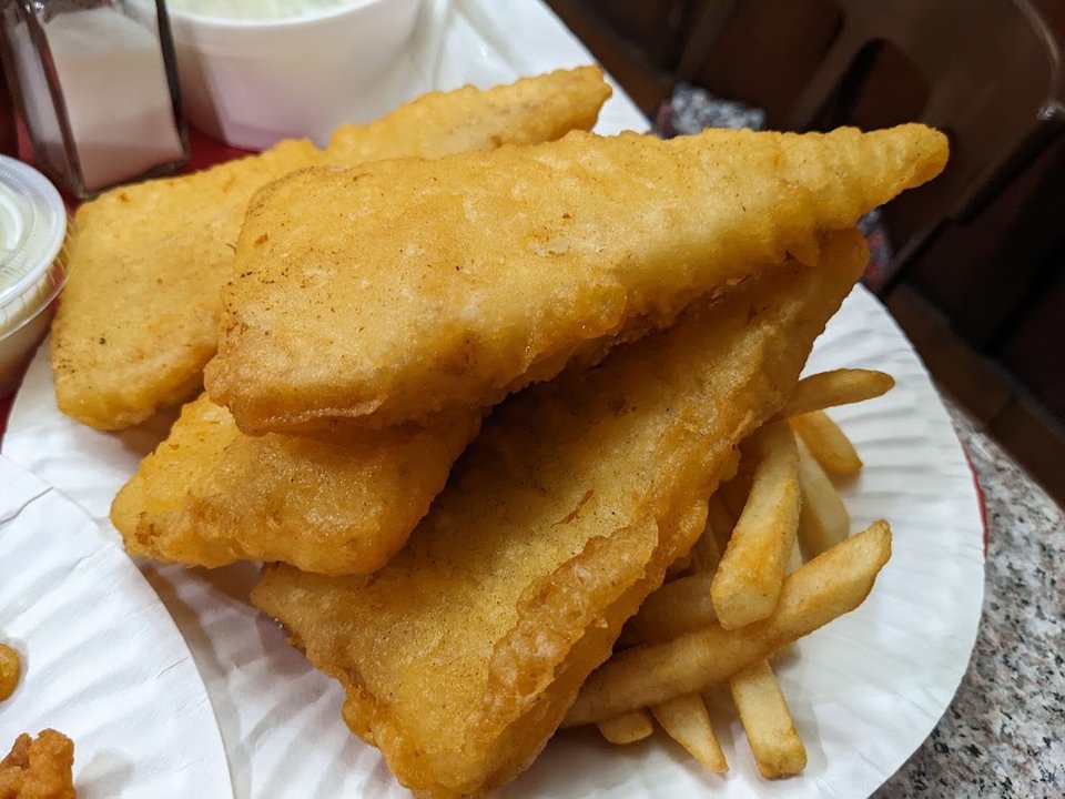 Counter menu with fried seafood and tartar sauce.